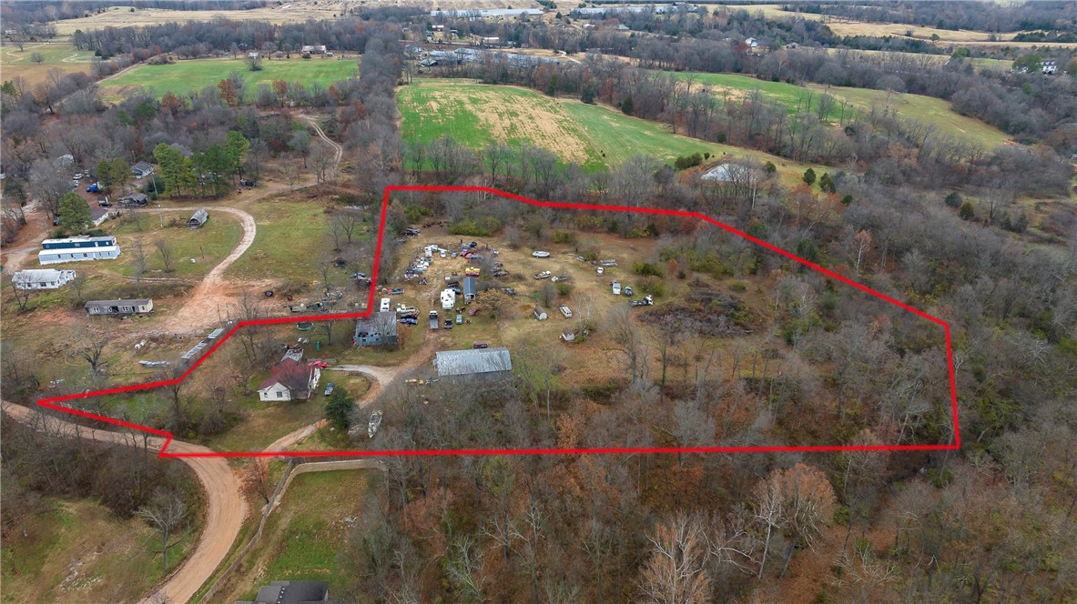 This 1904 1.5-Story, 3-Bedroom, 2-Bath, vinyl sided home situated on 7.64+/- acres with a covered front & side porch, 40x36 pole barn building with horse stalls with dirt floors, 36x60 pole building w/concrete floor shop area & small office at back & on the left front there is a 1bdrm apt & could bring income. Located out of town off CR 567 & HWY 412, could be a good starter or investment opportunity or bulldoze and start over new. Rough and rustic country living, needs lots of TLC, and current owner has some materials that could be left for the new owner to remodel or update if wanted. Multiple wall units for heat throughout and some window units for AC, multiple hot water tanks, septic in 2009-2010, main house roof in 2012, well water onsite & new owner will have access to 2-water taps (1-residential tap, 1-farm tap) if they choose to connect & a cistern 170' deep still on the property. Survey quotes available upon request. Disclosures, previous survey, legal description for 3-parcels & aerial in MLS.