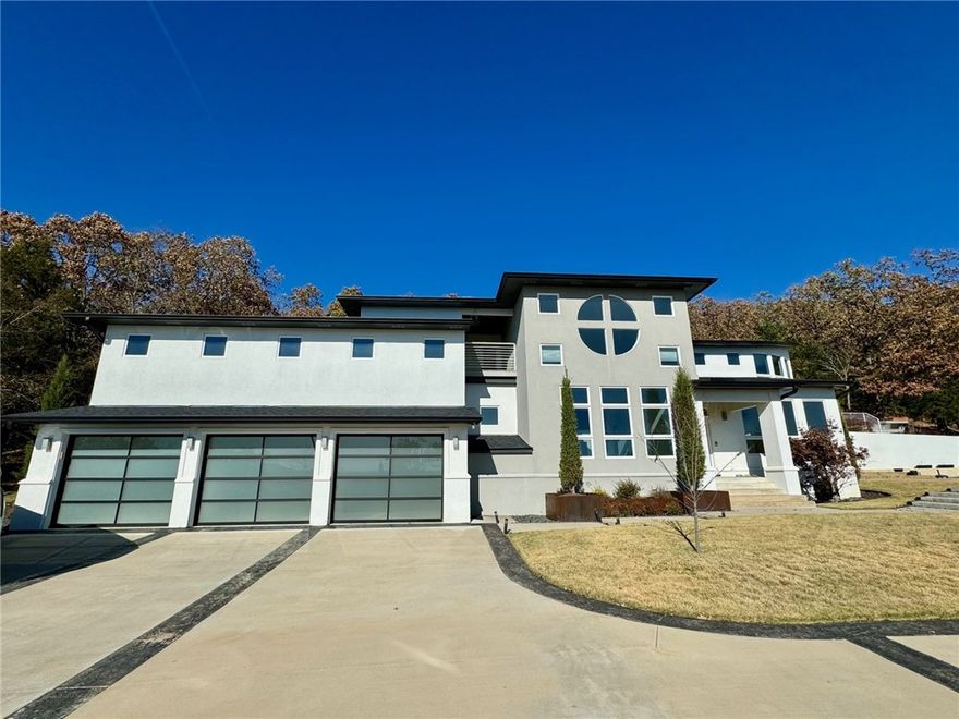 Amazing views from inside the home or from the in-ground pool and hot tub.  Multiple decks, patios, and a covered balcony look Southward across the Ozarks.  Home is a stylish contemporary situated on 3.78 acres of wooded privacy just minutes from the shops, restaurants, and schools of East Fayetteville.  Granite kitchen with gas cooktop, formal dining, and unique spiral staircase open up to a formal living room with floor to ceiling windows and double sided gas fireplace.  Media room, office or 4th bedroom. Custom wine storage/display area with bar. Primary bedroom has private patio and covered balcony.  Large walk in closet, with adjacent laundry, bonus room with bath and another walk in closet just outside of primary bedroom.  Bonus room has deck, hot tub and pool access.  New landscaping, and expanded circular driveway with plenty of parking for entertaining. Subdivision has access to White River.
