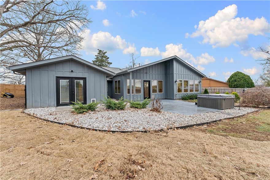 Rare Bentonville opportunity on nearly half an acre—an increasingly hard-to-find lot size in this location. This updated home offers space, flexibility, and value. Recent improvements include HVAC (2024), new roof and wood fence (2024), and a spacious primary bedroom addition (2024). Interior is freshly painted and highlighted by a bold Jade primary suite. Kitchen updated in 2021 with new cabinets, countertops, sink, and gas line behind stove. Additional updates include a new gas fireplace insert (2025) and exterior paint (2023). Outdoor features include a sprinkler system, large storage room, and 3-person hot tub that conveys. Flex space with vaulted ceiling is ideal for an office or second living area and could be converted to a bedroom with the addition of a door and replacement of one or two windows for operable egress. Nearly ½-acre lot offers ADU, guest house, office, or gym potential. Blocks from Ozark Mountain Bagel, Cronuts Donuts, Harps, and services.