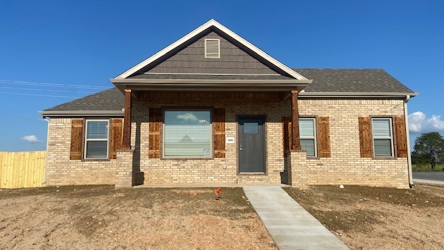 Stunning new construction—this single-story home sits on a corner lot and features 4 bedrooms, 2 bathrooms, and a spacious 3-car garage. The kitchen is equipped with stainless steel appliances, a gas range, microwave vent hood, pantry, and granite countertops. A large fireplace flanked with built-in bookshelves serves as a striking centerpiece in the living room. Elegant details include wood-cased windows with 2-inch blinds throughout. Enjoy great curb appeal with a large front porch, fully sodded oversized yard, and a privacy fence. The covered back porch and fully installed gutters add both comfort and functionality. A keyless garage door pad offers convenient access. The primary suite boasts an oversized tiled shower and a walk-in closet that connects directly to the laundry room, located near the garage for added convenience. Durable brick exterior construction ensures longevity and low maintenance.