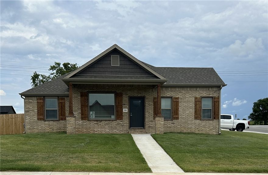 Stunning new construction—this single-story home sits on a corner lot and features 4 bedrooms, 2 bathrooms, and a spacious 3-car garage. The kitchen is equipped with stainless steel appliances, a gas range, microwave vent hood, pantry, and granite countertops. A large fireplace flanked with built-in bookshelves serves as a striking centerpiece in the living room. Elegant details include wood-cased windows with 2-inch blinds throughout. Enjoy great curb appeal with a large front porch, fully sodded oversized yard, and a privacy fence. The covered back porch and fully installed gutters add both comfort and functionality. A keyless garage door pad offers convenient access. The primary suite boasts an oversized tiled shower and a walk-in closet that connects directly to the laundry room, located near the garage for added convenience. Durable brick exterior construction ensures longevity and low maintenance.