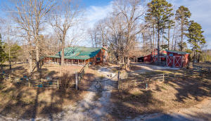 Check out this BEAUTIFUL Ozark Mtn. Property Only Minutes from the Buffalo River! This 3BR/2.5BA log cabin w/ hardwood floors, sits on 9.88 acres, & has paved road frontage! Relaxing Master BR & BA that walks out to a GIGANTIC fireplace & is a perfect place to unwind! Wooden Walkways go THROUGH the numerous Redbud trees take you to the Screened-In Pergola so that you can take in the terrific views! An additional 1BR/1BA cabin that could be a PERFECT nightly rental & it is great for the extended family to stay or for those big Holiday gatherings! Large, 30'X57' 9-stall Horse Barn, RV Shed w/ private septic system and Electrical service! 2 Chicken Coops styled like an Old West town! Enclosed back porch is FANTASTIC grilling & chilling spot! CHECK OUT THE DRONE VIRTUAL TOUR IN THE PHOTOS!!!