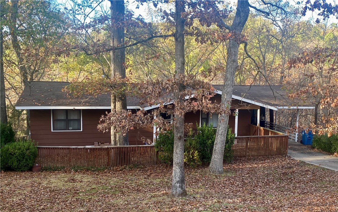 Welcome to your little cabin in the woods- in a neighborhood nestled in the rolling hills of Bella Vista! Situated on a secluded lot near area golf courses, parks, mountain bike trails, the Razorback Greenway, swimming pools and recreational activities like hiking, kayaking and tennis. Located just north of Lake Ann. There are also several other area lakes. 2 bedrooms, 2 baths, open kitchen and living room area with eat-in breakfast nook, hardwood floors. Fenced in back yard area. Propane tank was just filled. All electric except for heater. HVAC system replaced in 2022. For all the wonderful amenities that Bella Vista is known for go to bellavistapoa.com for details.