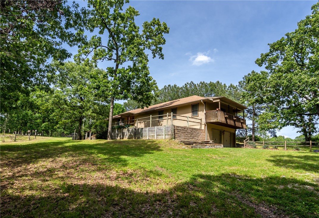 Welcome to this private retreat nestled on 19.89 Acres of serene beauty. This magnificent 3 BR, 2 BA home spans 2212 Sq Ft offering ample space for relaxation & versatility. The primary BR is a true haven, featuring a flex room that can serve as a private sitting area, a home office or even a nursery. The primary BR grants easy access to the laundry room, making daily tasks a breeze. With a split floor plan, this home ensures privacy & a seamless flow throughout. Additionally, peace of mind is guaranteed with an underground storm shelter, providing safety during inclement weather. There is a two-car attached garage on the lower level, accessible via an elevator, ensuring security & convenience, In addition, a 1 car detached garage is also available, offering additional storage. The property boasts a 16 X 20 pole barn, with a mix of wooded & open land. Convenience is at your fingertips, as this private oasis is located near Bentonville, XNA, dining & shopping. Come & experience serenity & versatility here.