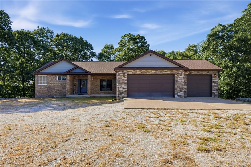 Perched on 5 scenic acres, this mountaintop retreat offers breathtaking year-round views of the Ozarks and Table Rock Lake from massive entertaining decks designed to soak in the beauty from sunrise to sunset. The 1,828 sq. ft. main level is handicap accessible and features an open-concept layout with spacious living and kitchen areas, a designated dining room, and walls of windows that bring the outdoors in. Thoughtfully designed with 4 bedrooms, one currently serving as a dedicated office, while the remaining 3 bedrooms each offer private en suite baths with walk-in showers and generous walk-in closets, creating true primary-suite comfort for family or guests. A whole-home generator adds peace of mind, and all appliances convey at no cost to the buyer. The 1,505 sq. ft. lower level is ready for the new owner’s vision with endless possibilities for additional living space, guest quarters, or workshop.