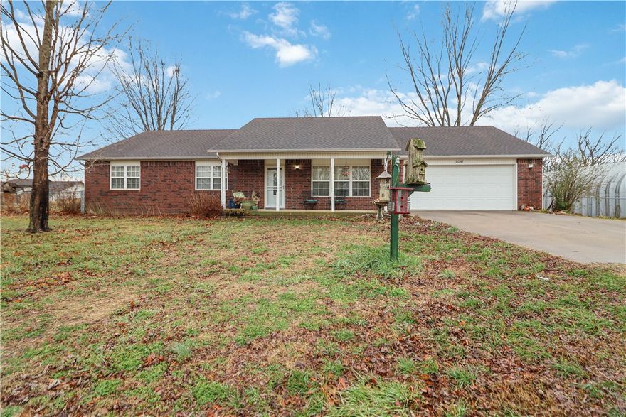 Beautiful all-brick, single-level home on 1.97 level acres within the Pea Ridge city limits. This well-maintained 2,104 sq ft home features a spacious kitchen with ample cabinetry, a gas-log fireplace in the main living area, and a bright 24x16 sunroom offering additional living space. The home includes three bedrooms and two full bathrooms, plus a large laundry room with utility sink and an oversized attached two-car garage.

Outdoors, enjoy 1.97 acres with mature landscaping, a 25x37 detached workshop with concrete floors and lighting, and a 10x18 storage building. Includes a storm shelter in the backyard. A covered front porch and patio complete this property offering space, privacy, and convenience just minutes from town.