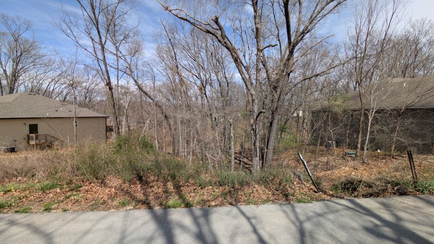 Buildable lot with water and sewer access steps from the Metfield Clubhouse and golf complex! Quiet street. Survey Available. Located within the coveted Bentonville School District. This property offers convenient access to Bella Vista's renowned trail system, lakes, and golf clubs. This site is situated a few hundred feet away from the Mulligan and Rago Trails, and in close proximity to Lake Brittany, which is known for excellent fishing and boating opportunities. This wooded environment near Bentonville is suitable for custom home construction or as a long-term investment.