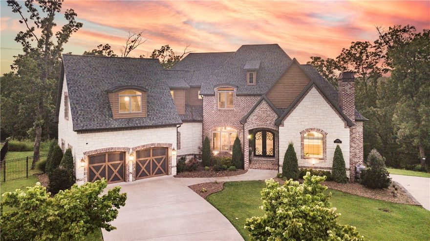 This stunning 5-bedroom, 5.5-bath home, is tucked away in a cul-de-sac on a private 2-acre lot within the exclusive Oak Tree Estates! Breathtaking tree-top views stretch for miles, creating an oasis just 10 mins from Bentonville Square. The kitchen has two walk-in pantries, an oversized island, and pro-grade appliances, ideal for cooking and entertaining. The spa-like master bath offers a soaking tub, gas fireplace, and spacious walk-in shower with a rainfall feature. The bonus room with full bath is perfect for play or large bedroom. The expansive lower living area has a full wet bar and gorgeous office! Outside you’ll find a built-in grill on the main deck and a shady lower-level patio, both with fireplaces. Main level 2-car garage, plus a bonus 2-car garage below with its own driveway and entry. This one-of-a-kind community has a clubhouse, gym, pool, and sports courts- full of kids and great families. Nature lovers rejoice—access to the scenic Coler Mountain bike trail from your back door!