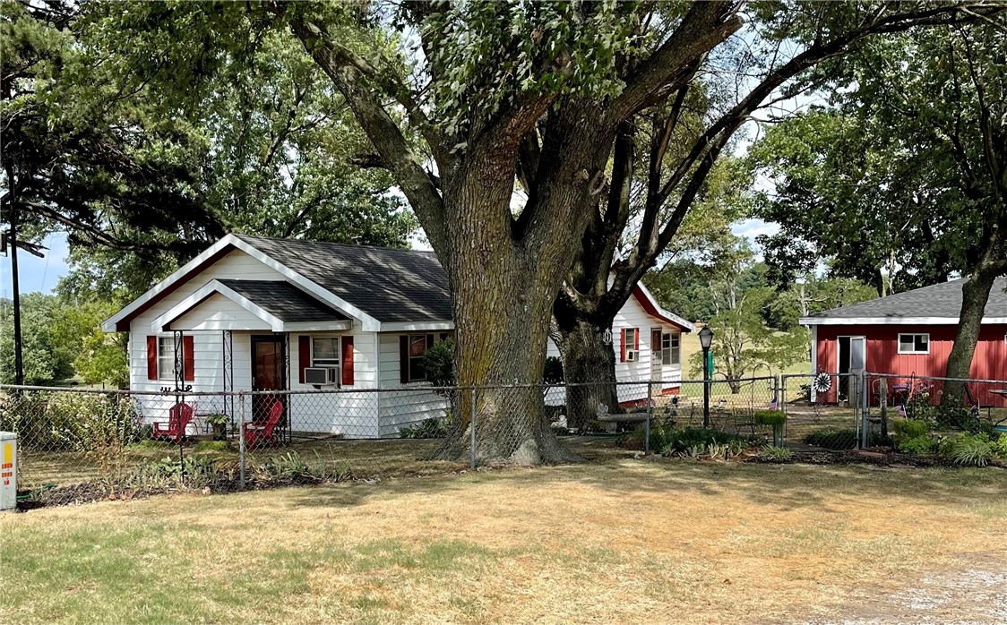 Wow! A fantastic location with 15 acres right by the high school! Just outside city limits. This property includes a detached garage with a great workshop, barn, 2 ponds and a well-maintained home. The home features 1,776 sq. ft., 4 BR, 2-1/2 BA plus a fantastic very large, enclosed back porch not included in the square footage. Large eat-in kitchen with lots of storage space, and a storm shelter also included. What a beautiful yard! Don't miss this one.