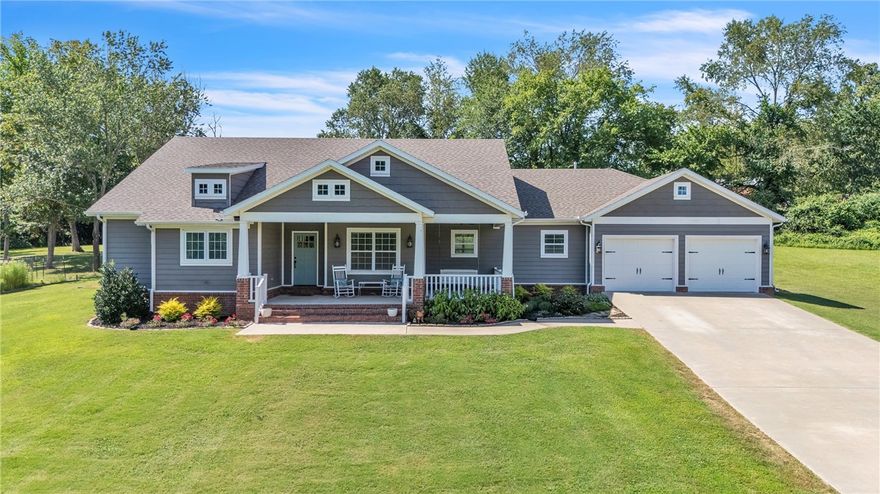 Welcome home to this stunning 4 BR 3 BA craftsman-style farmhouse on 6.23 acres. Nestled on a South facing hillside, this unique one-owner custom-built home offers the ideal blend of privacy & community.  Enjoy serene countryside living while still benefiting from subdivision access to amenities including pool, clubhouse, & play area. The interior features an inviting open-concept layout with bedrooms on corners surrounding the central living space and large screened-in porch. The kitchen is a true gathering space, complete with floor to ceiling cabinets, pantry, gas range, coffee bar, & oversized island with bar seating & adjacent dining space-perfect for casual family meals or entertaining guests. Great primary suite with soaker tub & separate walk-in shower. Outdoor recreation space includes a 30'x50' rear patio perfect for pickleball or gathering around the outdoor fireplace, a mulched playset area, 100' zipline, & 40'x30' fenced garden with raised beds. Deep 2 car garage with storm shelter safety room.