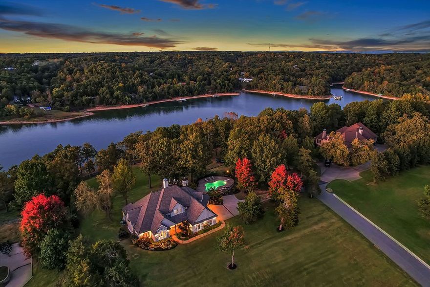 A rare fusion of luxury and lifestyle embodies this lakeside masterpiece nestled on 5 private acres within the gated South Mountain Estates. Every detail tells a story with this grand open floor plan of high-end craftsmanship from the cathedral ceilings framed with wooden beams and cascading sunlight throughout the spaces designed to inspire connection. The gourmet kitchen serves as the heart of the home, featuring stunning waterfall quartzite counters, custom cabinetry, and a built-in grill that unites function with flair. Retreat to the main level primary suite, which provides a sitting area, dual walk-in closets, and a spa sanctuary with heated floors, towel warmers, soaking tub, and multi head shower create a haven of calm. Step outdoors to an enchanted resort-like retreat including a heated gunite pool, koi pond, soothing waterfalls, firepit, gazebo, and an expansive deck. A private dock with covered slip, lift, and swim deck offers effortless lake access completing this extraordinary waterfront escape.