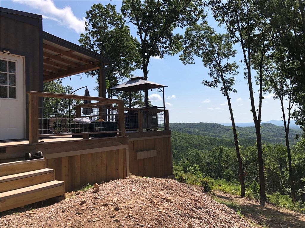 Modern Cabin Retreat with Breathtaking Views on 7.69 Acres! A modern take on the classic cabinārustic on the outside, sleek and stylish within. The property spans 7.69 acres atop a high ridge line offering expansive sunrise views and peaceful seclusion. A powered gate welcomes you home, while a secondary drive provides leveled parking for trailers, ATVs, and boats. Inside, find a bright clean living space with two bedrooms featuring gorgeous valley views. The kitchen shines with a Samsung high-efficiency refrigerator, Galanz combo oven (microwave, air fryer, and convection), plus KitchenAid electric cooktop and dishwasher. Step outside to 1,000+ sqft of deck space featuring an 8-person Nordic Spa, gas fire pit, grill, smoker, and dry barāan entertainerās dream in the heart of nature. Guests will love the dedicated RV parking with 50 AMP service. Wander down the trail to explore the bluff, small cave, and wet-weather creekāor forage for morels, ginseng, and other Ozark treasures. Seeing is believing!