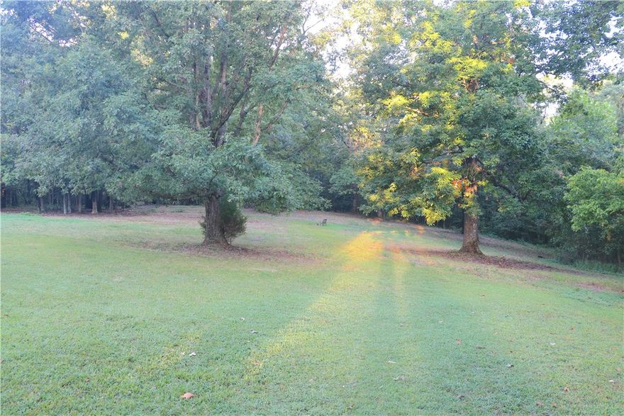 This stunning Benton County property offers a perfect combination of seclusion and
accessibility, situated at the end of a quiet dead-end road just outside Pea Ridge, AR. Enjoy
the convenience of quick trips to the metro area while embracing a peaceful country lifestyle.
Equipped with public water, electricity, a generator, and a septic system, the land features a
mix of open spaces and towering timber, making it an ideal setting for your dream home or a
family homestead.
As you approach the property, you'll find a two-bedroom, two-bath mobile home accompanied
by several outbuildings, storm shelter, and a small garden area. The landscape beautifully
merges open fields with mature oak trees, providing endless opportunities for usability and
expansion. An ATV trail through the woods leads to a seasonal creek that runs through the
property ideal for wildlife and setting up tree stands. Additional trails can easily be carved into
the timber for accessibility of the entire perimeter.