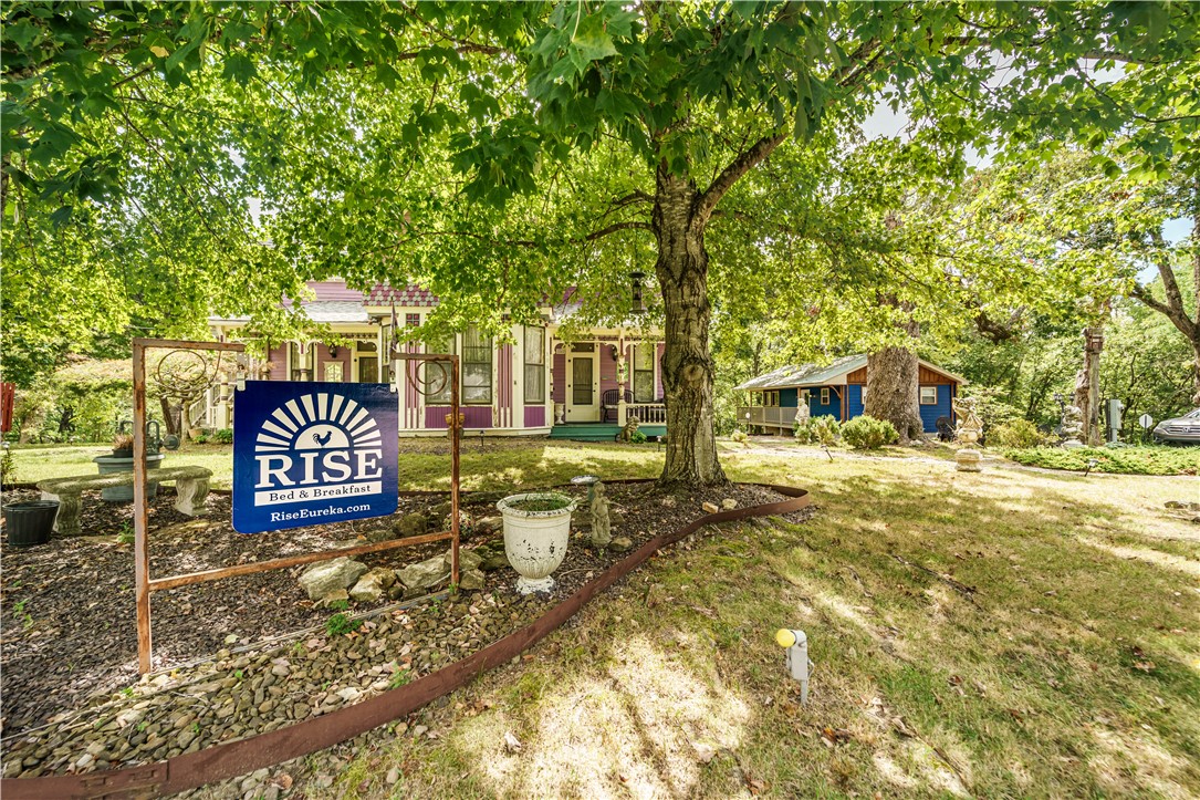 Historic Charm in the Heart of Eureka Springs! This vibrant Victorian radiates history and character w/ its two inviting front porches, ornate trim, and mature trees. Step inside to discover rich woodwork, French doors, tall windows with lace curtains, gleaming hardwood floors, and vintage touches throughout blending timeless charm w/ modern comfort. Each room tells a story, thoughtfully updated to preserve original craftsmanship while adding livability. Large heated & cooled sunroom offers the perfect spot to relax or entertain while surrounded by natural light. This home is grandfathered as a bed-and-breakfast, proudly holding the honor of being the first B&B officially permitted in Eureka Springs, & has been welcoming guests for over 40 years. Outdoors, enjoy peaceful moments on the tree swing, take in the neighborhood charm, & embrace the vibrant community. All this, while being moments from historic district, shops, restaurants, & galleries, yet nestled in a serene, setting.