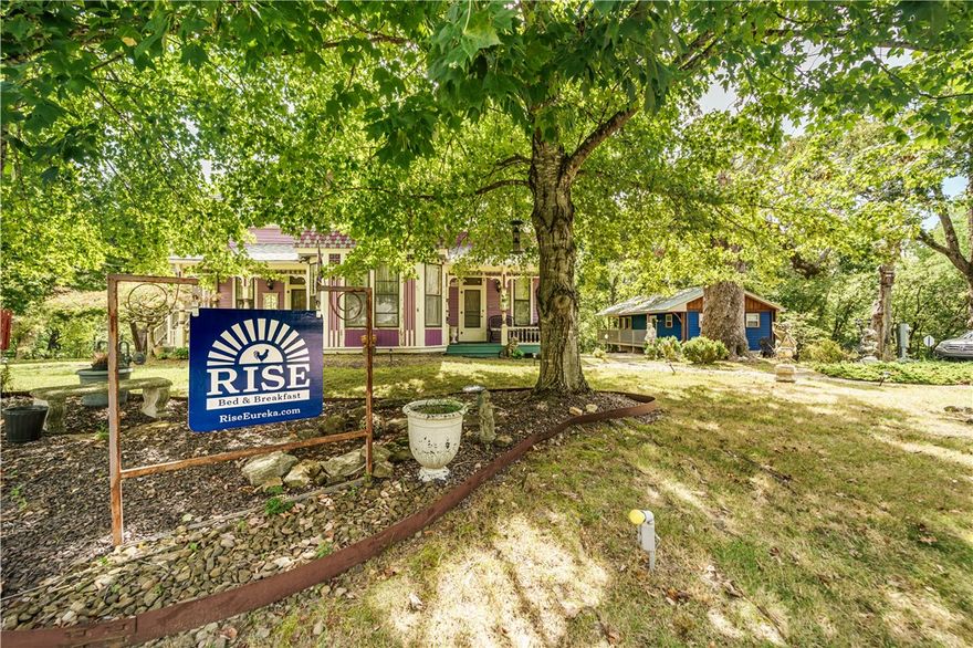 Historic Charm in the Heart of Eureka Springs!  This vibrant Victorian radiates  history and character w/ its two inviting front porches, ornate trim, and mature trees. Step inside to discover rich woodwork, French doors, tall windows with lace curtains, gleaming hardwood floors, and vintage touches throughout blending timeless charm w/ modern comfort. Each room tells a story, thoughtfully updated to preserve original craftsmanship while adding livability. Large heated & cooled sunroom offers the perfect spot to relax or entertain while surrounded by natural light. This home is grandfathered as a bed-and-breakfast, proudly holding the honor of being the first B&B officially permitted in Eureka Springs, & has been welcoming guests for over 40 years. Outdoors, enjoy peaceful moments on the tree swing, take in the neighborhood charm, & embrace the vibrant community. All this, while being moments from historic district, shops, restaurants, & galleries, yet nestled in a serene,  setting.