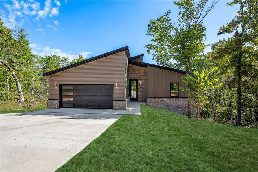 Welcome to this modern new-construction beauty, perfectly situated in the heart of Bella Vista. With golf, a fitness center, and Loch Lomond just minutes away, there’s no shortage of ways to enjoy the good life. This home offers three bedrooms plus a pocket office all bathed in natural light with fantastic wooded views that bring the outdoors in. Inside, you’ll find quartz countertops, high-end LVP flooring, designer tile surrounds, and meticulous craftsmanship. A deep garage provides extra storage space, while the covered back porch is the perfect spot to unwind and take in the scenery. Come see for yourself why this one stands out among the rest.  Modern living meets Ozark charm!