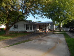 Nice 3BR, 1BA home located on a corner lot a few blocks off the Berryville square. New roof in 2022, new HVAC 4-5 years ago, new sewer lines in 2021, lots of upgrades including some electric work with a 50 amp RV plug added, wheelchair ramp, hand rails in hallway, and modified tub/shower, nice covered patio on back and storm cellar under utility room. 24 x 36 detached shop with 12 foot tall and 18 foot wide garage door with opener, 2 other storage buildings, a one car carport and a fenced yard.