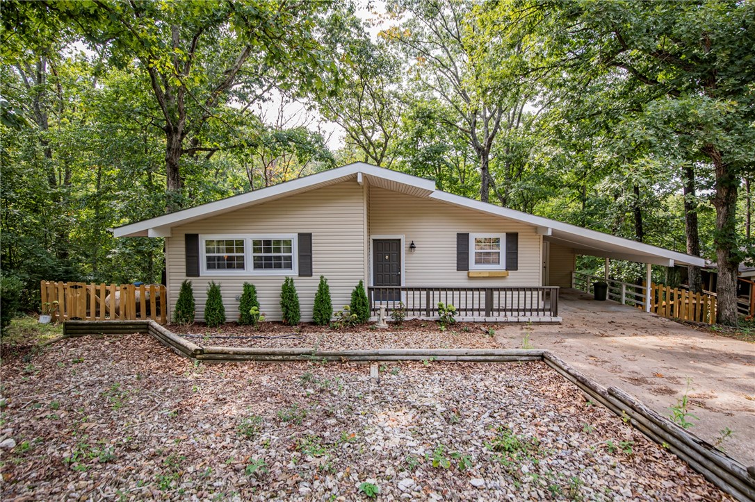 Charming updated 2 bed, 1 1/2 bath cottage home in a tranquil setting near Lake Windsor, numerous bike and walking trails and close to Bentonville. New granite countertops, newly tiled bathroom, new luxury vinyl plank flooring throughout and new paint. Large living area with high ceilings and skylights opens to both the newly remodeled kitchen as well as the welcoming sunroom with lots of large windows bringing nature inside! You will be able to cook your meals with an unobstructed view throughout the living area to the beautiful forest. Numerous gardens have been added along with a picket fenced in back yard. Separate heated and cooled room in basement perfect for a workshop, hobby room, mancave or just for lots of storage. New roof in late 2022. Lots of storage space attached to carport. Come see it today!