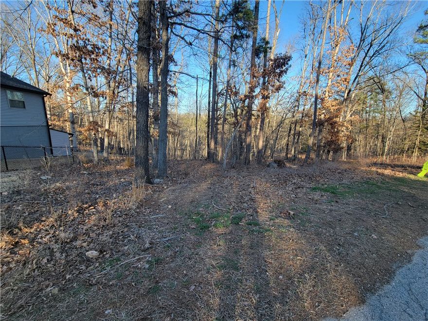 This lot has access to SEWER!!!  Only a mild slope on the front half of this lot and is nicely shaped for your new home.  Come check out this lot and see how peaceful and serene it would be to live on this street.  Bentonville schools!