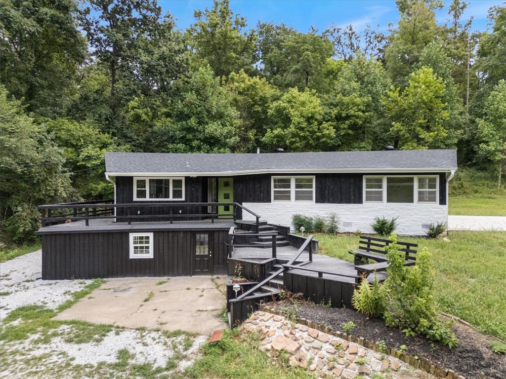 Nestled atop a gentle hill and surrounded by beautiful, mature trees, this thoughtfully remodeled older home offers the perfect blend of comfort, charm, and natural beauty. Set on 4 acres of serene countryside, the home has a new roof & feels like a private vacation retreat.
Kitchen & dining area are inundated with natural light that invite the outdoors in. A cozy wood-burning fireplace adds warmth and character to the living space, making it ideal for quiet evenings or entertaining guests.
Step outside onto the expansive wraparound porch, where panoramic views of the entire property unfold—perfect for morning coffee, sunset watching, or simply soaking in the peaceful surroundings. Downstairs, two inviting rooms provide a welcome escape during warm summer months.
At the back of the home, an enclosed sunroom offers a year-round oasis, ideal for relaxing, reading, or enjoying the views regardless of the weather. This unique property offers an opportunity to own an updated home with the feel of a rural retreat.