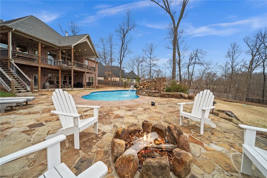 Experience the luxury of this estate home just minutes from the Bentonville Square! Nestled on two acres in the desired Versaille neighborhood, you'll love the privacy this home provides tucked away on a quiet cul-de-sac. Whether you're entertaining in the summer months or the heart of winter, there's ample space to enjoy. The large saltwater pool with fountain is the showpiece of the oversized backyard-- complete with an adjacent built-in firepit. Choose the perfect morning coffee spot on the spacious deck or the basement patio with birds, wildlife & soothing waterfall. The walk-out basement, complete with picture windows overlooking the pool, offers a flex space, lots of storage, built-in library & a half-bath with its own entrance to the pool. If you're looking to retreat from the hustle & bustle,the serene primary suite has its own deck entrance, new carpet, and spa-like bathroom complete with an oversized shower. Location couldn't be better: 5.8 miles to I49,3 miles to Coler,& 3.7 miles to Razorback Greenway..