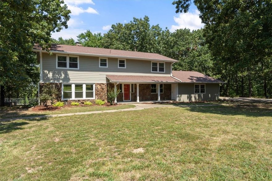 Discover this stunning 5 bedroom, 3 bath home just minutes from downtown Prairie Grove, offering the perfect blend of privacy and accessibility. The welcoming formal entry with its grand sweeping staircase sets the tone, complemented by wood floors throughout. You'll love the spacious kitchen with ample cabinetry, modern appliances, and an inviting dining area. Relax in the sunroom, bask in natural light, or gather around the wood-burning fireplace in one of two living rooms. Upstairs, the expansive primary suite features a striking rock fireplace and a huge walk-in closet with built-ins. Step outside to find amenities for livestock, including a fenced arena, barn with tack room and loft storage, and a serene pond where you can unwind with a day of fishing. With incredible space for hobbies and entertaining, excellent storage throughout, charming built-ins and a harmonious blend of sophistication and comfort, this home offers everything you need for peaceful country livingājust moments from town.