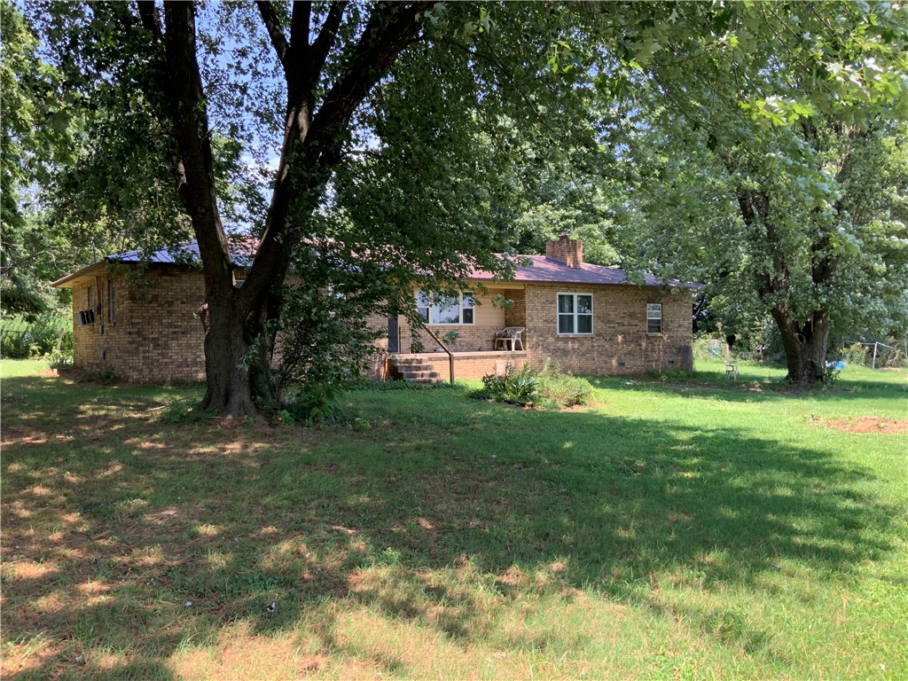 Well built, 4 bed 2 bath home on 1.7+/- acres. Beautiful brick exterior and metal roof make this home very low maintenance. This older home with good bones has plenty of room that can be used for whatever your life requires. Located only 20 minutes from Fayetteville and 15 minutes from Huntsville, this rural property has the out of town feel while still being close to everyday amenities. OzarksGo fiberoptic, for the remote worker. Small buildings located behind the home were used to keep animals, on being used as a dog kennel at one point. Ground is open and level, giving you freedom to make the most of what this property has to offer, while still having lots of large shade trees overhead. This home is sold as-is.