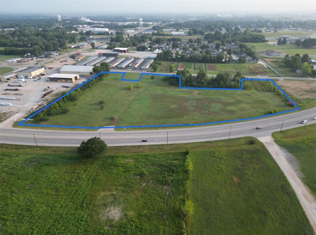 8+ acres m/l of open ready to develop land. Extreme high traffic area with over 800 feet of hwy 412 frontage also fronts kenwood street. Countless options. All utilities on or near site. Seller may consider divide.