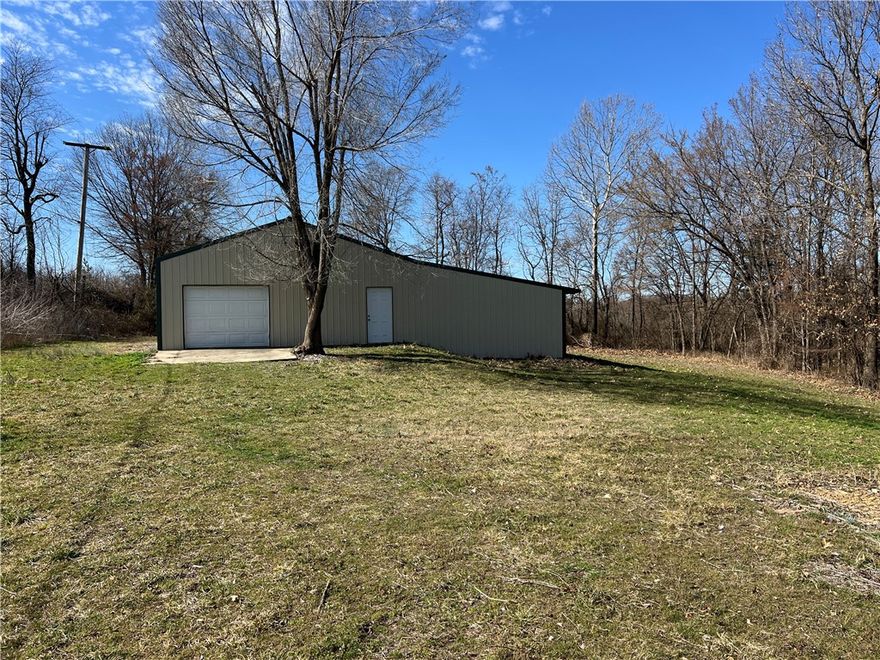 Tucked at the very end of the road on the edge of Green Forest city limits, this 1.63-acre tract offers space, privacy, and flexibility in a predominantly commercial corridor. The property is fenced and includes a wide drive-through gate suitable for trucks, trailers, and vehicles. The 1,680 SF metal building features a concrete floor, single overhead garage door, two man doors, and an attached lean-to for additional covered storage. Previously used as a vehicle restoration warehouse, the structure provides wide-open interior space ideal for storage, equipment, workshop use, or future business operations. The land is mostly cleared and level, with mature trees along the edges and room for expansion or additional improvements. Electric service is available at the pole, city water is nearby (buyer to verify connection), and a septic permit was obtained in 2006 (no system installed). A strategic acquisition for buyers seeking long-term utility and growth potential.