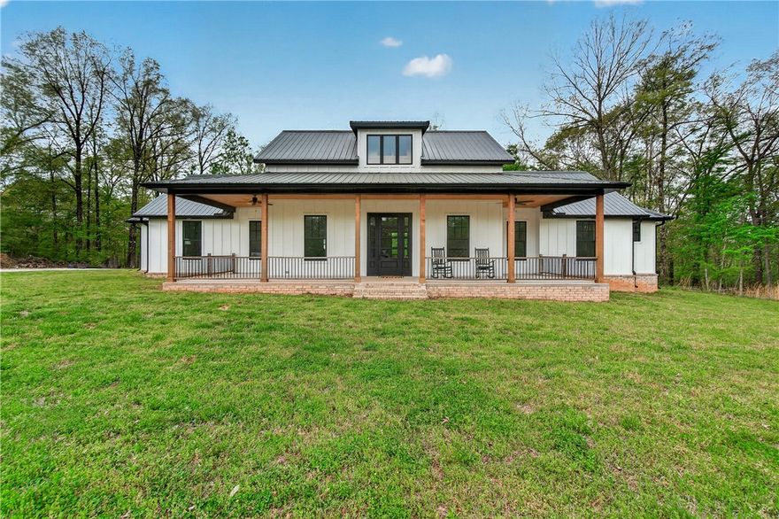 Like-new farmhouse-style home on 5 acres near Lake Wedington, where peaceful living meets everyday convenience just minutes from town.
Step inside to an open, light-filled layout centered around a stunning chef’s kitchen featuring double ovens, a 9-foot island, quartz countertops, commercial-grade gas cooktop, farmhouse sink, Café appliances, and a butler’s pantry. 
The oversized primary suite offers a quiet retreat with a built-in window bench framed by four large windows overlooking the backyard. The en-suite bath includes dual vanities, a dedicated makeup area, and a spacious walk-in closet with built-in dressers.
A standout feature is the finished bonus room off the garage, complete with a mini split, perfect for a movie room, game room, home office, or private guest space.
Additional highlights include a dog wash station in the laundry room, energy-efficient foam insulation, instant hot water, two furnaces, and LVP flooring throughout and carpet in the jack-n-jill bedrooms.