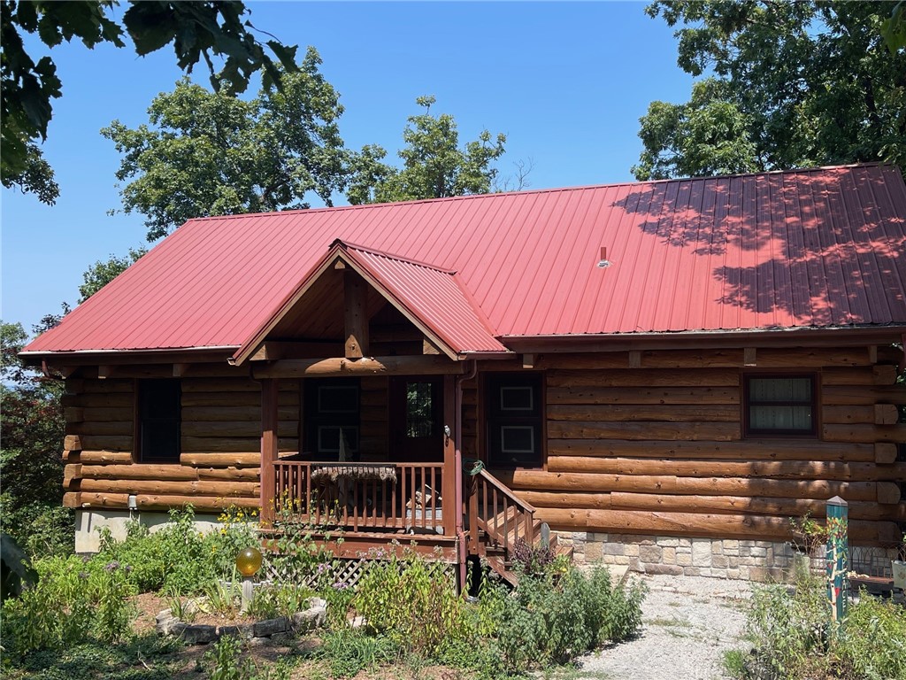 Charming Country Retreat with Modern Comforts!
Welcome to your dream home nestled in the heart of serene countryside living! This beautiful 3-bedroom, 2-bathroom log home sits on 14 acres m/l with mature trees, open skies, and room to breathe.
• Inviting Front Porch – Perfect for morning coffee or evening relaxation with a custom built waterfall running through the natural bluff line.
• Open-Concept Living Area – Bright and airy with large windows, and a cozy fireplace.
• Outdoor Living Space – Includes a large deck and shaded backyard ideal for entertaining, gardening, or simply enjoying nature. Home is constructed with Douglas fir logs and spruce wood for floors
This property offers the perfect blend of rural charm and contemporary updates—ideal for families, retirees, or anyone seeking a peaceful lifestyle without sacrificing modern conveniences. This home offers a back-up generator, solar panels and a permanent green house. Located near Table rock lake, Kings River, Eureka Springs