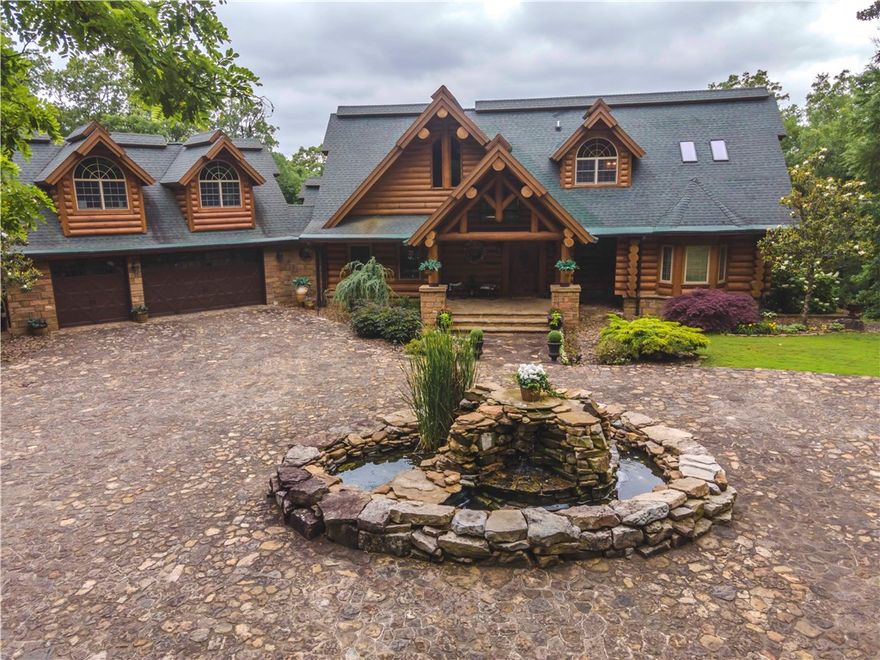 Gorgeous log home that has it all with a million-dollar view overlooking the valley. You can see for miles from these 12.62 private acres! Cobblestone driveway leading up to this 3-story home has 10 streetlamps (on timer) lining the entire driveway. The 5,661 SF heated home includes a 496 SF apartment over the attached 3-car garage with its own kitchen & bathroom. Other features of the home are 5 BR, 4.5 BA, giant game room on bottom floor with a beautiful rock fireplace & walk-out patio, Pella windows & doors, granite countertops, wrap-around porches, plus a hidden safe room or storm shelter & specialty plumbing system. Also included on the property are 40x70 detached 5-car garage, 403 SF mancave or she shed cabin, 4-sided native stone waterfall, outdoor landscape lighting around the house & property, firepits, stone picnic table/benches. Entire main home has been stripped, sanded, coated, stained. Good for 12-15 yrs. Just minutes to town. See extensive list of amenities. See in person to truly appreciate it!!