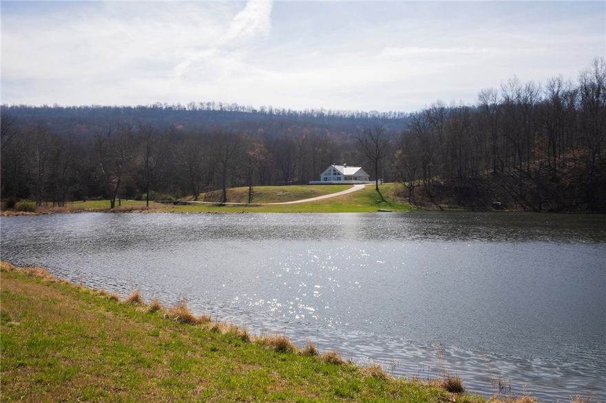Escape to this 2,000 sq ft private getaway built in 2010 & sits on 375 AC with some of mother nature’s best in natural surroundings . Enjoy weekends & holidays in this beautiful cottage minutes from town. This home features 2 bedrooms, a loft, 2 full baths, wood stove, & two car drive thru garage. A large covered front porch provides spacious outdoor living for drinking coffee or watching a wonderful sunset. Kitchen is equipped with high end appliances & eat in bar. Home is complete with a full home generator & security system with sliding doors to cover windows when vacant.  Water source is well water & gas source is a 1,000 gallon buried propane tank. In addition, there is a 22x30 barn for storage.  If hunting/fishing are on your list of activities, take advantage of the spring fed 3 AC stocked fishing lake & multiple food plots/ponds/deer stands & feeders for managing your deer & turkey. Multiple ATV trails throughout the property for exploring. Property is 30 mins from Fayetteville & only ½ mile of gravel road.