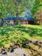 2.38 acres on the west side of town! This home has so much to offer with three bedrooms, 1 full bath & 2 1/2 baths, a large living room, a sunroom, and a large enclosed carport both with air conditioning, and detached garage. Located at the end of a dead end street, enjoy the trees and privacy that surround this home!