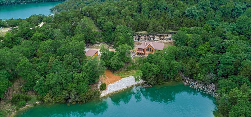 Custom built,  energy efficient hybrid log home with 2" x 6" walls and log siding.   So much attention to detail that there is not enough room to list!  Views of main channel of lake, solar shades, gorgeous bluffs in rear of home with lighting, leatherized granite countertops, tongue and groove tie beamed ceilings, Asian Walnut hardwood floors throughout, in floor heating system in master bath, 4 decks and screened in porch to name a few.    Home has full basement with 9' ceilings with huge workshop.  Some furnishings to convey. 10 x 24 boat slip with lift to convey. Ranger in garage to convey for use to boat slip etc.  Proof of funds needed with offers