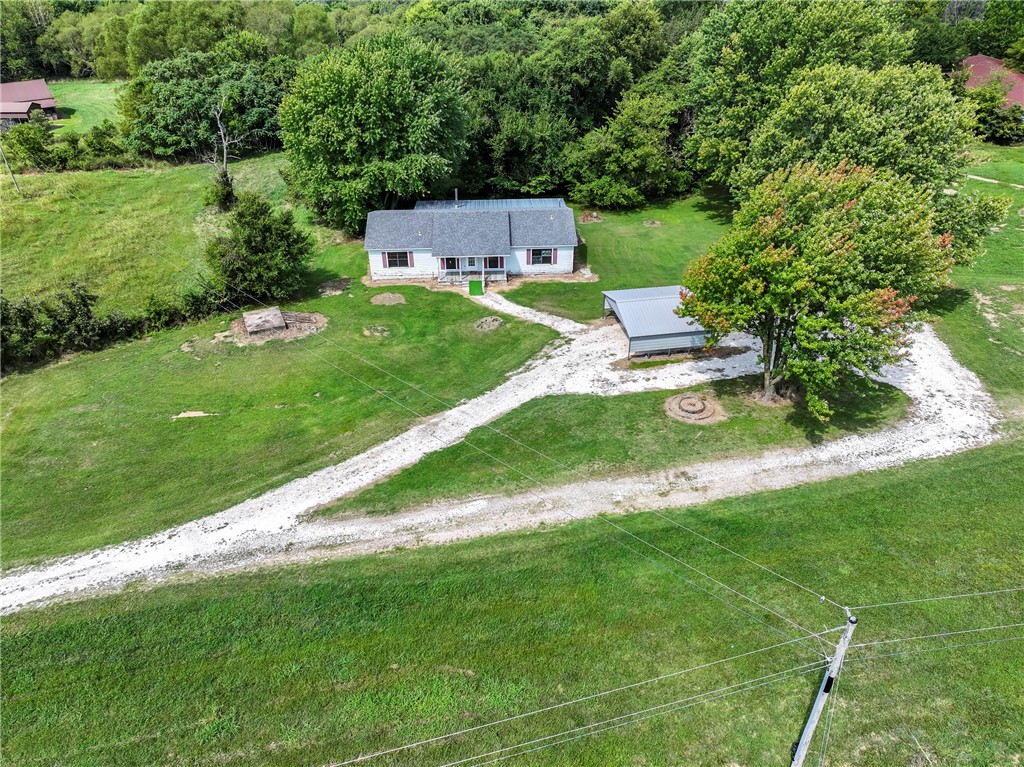 Welcome home to this cute 3 bed 2 bathroom home on 32.5 acres. Walking into the home you are greeted by the natural sunlight and a beautiful view off the back porch looking out into the woods. The heart of the home is it's expansive kitchen, complete with a large island and abundant cabinet space. With OzarksGo available it makes the office space even more convenient for anyone working from home. Spend your evening outside on the expansive covered back porch offering breathtaking views, perfect for hosting or just winding down after a long day. Despite its private setting, it's just a short drive to the scenic Lincoln Lake, perfect for outdoor enthusiasts. The property is conveniently located for easy access to both Lincoln and Siloam, offering the best of rural living with city conveniences within reach. Pasture for livestock and plentiful wildlife. Whether you're looking for a serene place to raise a family, a peaceful getaway, or a home with room to grow, this property offers it all. Make it your own today!