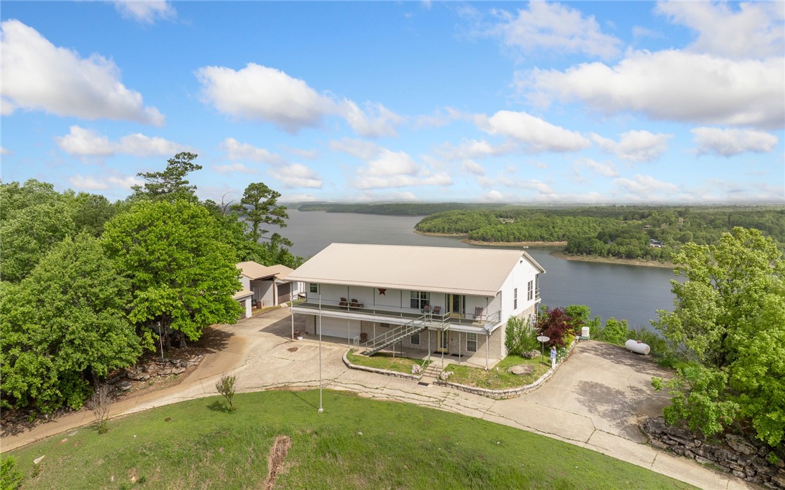 Welcome to your private lakeside haven! This exceptional 4-bedroom, 3-bath home offers 3,000+ sq ft of well-designed living space on 5 peaceful acres with sweeping 180° views of Bull Shoals Lake. Enjoy year-round comfort with an open-concept layout, spacious living room, and wall-to-wall windows that frame the lake. The kitchen features ample counter space and storage, flowing into the main living area—perfect for entertaining. The lake-facing primary suite includes a private bath and walk-in closet, with generous additional bedrooms for guests or family. A full-house generator ensures peace of mind. Relax or entertain outdoors on expansive decks, patios, and covered spaces.
Don’t miss this rare opportunity—schedule your private showing today!
