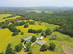 A gently rolling drive across the beautiful pasture ends inside the fenced lot of the home and shop buildings. Parking, equipment storage, space for pets, livestock, toys, friends or family won't be a problem with the circle drive, huge shop buildings, 2 carports, and even horse stalls. The home boasts a large kitchen with double ovens, and all 5 bedrooms on the lower level. There is an enormous master bath suite, and a large outdoor patio for entertaining or relaxing. Upstairs has two large dens and another full bath, creating potential for a 6th bedroom. There is also a dedicated office on the main level. The easternmost shop is approximately 30 x 75, with electric roll up doors. This shop is mostly concrete floored, but also has partial dirt floor for the two horse stalls