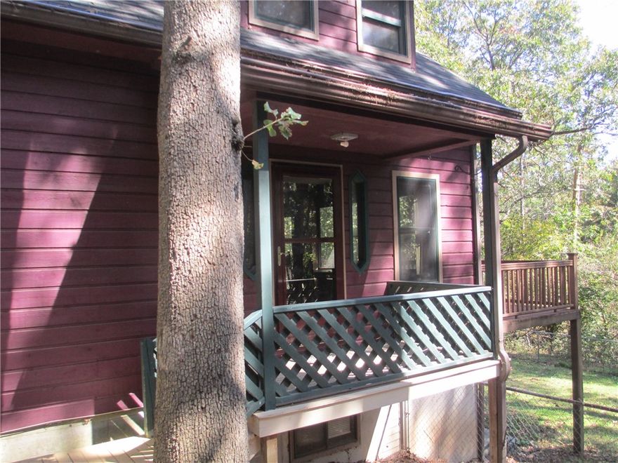 If your looking for a separate space for an artist studio, man cave, she shed or wood shop EUREKA, you've found it! Nestled on 2 wooded lots this lovely 4 bed/3 bath home is convenient to all Eureka Springs offers yet just outside the city limits. The main level offers open living dining and kitchen area all warmed by the large gas log fireplace. A bedroom full bath, additional sitting room and deck access round out this level. 
Offering total privacy the upper level houses the primary suite w/full bath, built-in shelving, walk-in closet & access to the deck.  The two bedrooms on the lower level share a Jack & Jill bath, laundry area, mechanical room, tons of closet space & walkout to the fenced back yard.  The bonus building is unattached from the main house provides privacy & has the potential for generating additional income.