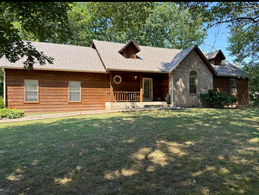 Welcome to 2 Wendron Ln. A Beautiful home featuring 1502 sq ft, 2BR/2BA (with large office) on a wooded corner lot right off of Trafalgar. Riding distance from bike trails, the Greenway, and Dogwood golf course. The exterior features a mix of wood siding and brick accents. Your front porch leads into a warm open living space with vaulted ceilings and brick fireplace. The kitchen offers generous cabinet space and a breakfast nook. Bedrooms are spacious with a large office just off of the living room. Use it as a second living area or a 3rd bedroom. Step outside to enjoy a large deck, partially covered and screened in, perfect for morning coffee as well as entertaining. A wonderful blend of nature and convenience. Extra lot right outside the back deck is offered for a total of $307,000.
