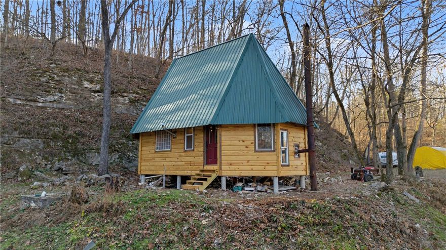 Nestled on 4.78 wooded acres, this rustic 1-bed/1-bath primitive cabin offers peaceful seclusion and natural beauty — ideal for hunters, weekend retreats, or anyone seeking an off-grid escape. The approx. 800 sq ft cabin features new log-cabin-style siding, a newer metal roof, and a cozy wood stove for heat. The property currently uses a spring-fed water system, with a previous septic location and potential to add a well if desired. Inside is a simple, functional layout ready for your personal touch and customization. Outdoors, enjoy quiet surroundings, abundant wildlife, and a seasonal waterfall that flows just behind the cabin during rainy months. With privacy, charm, and room to improve, this property is a rare opportunity to create your own secluded getaway.