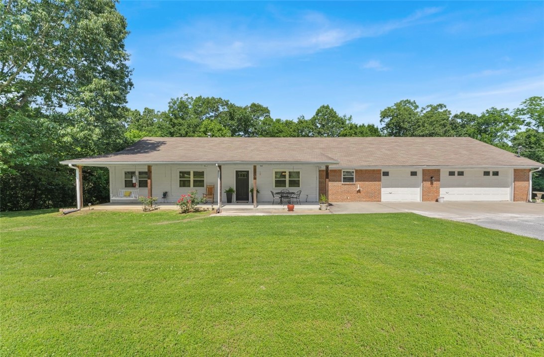 This well maintained-for property offers the perfect blend of privacy, space, and convenience. Nestled on 5 surveyed acres in a great location, this home features a gorgeous yard with large, mature trees that provide both shade and stunning scenery. Inside, you'll find a spacious living area and dining room filled with great natural light, making the space feel warm, inviting, and functional. The expansive kitchen offers tons of counter space and includes a cozy eat-in area, perfect for casual meals or morning coffee. The home itself is in excellent condition, with new windows less than 5 years old, a roof replaced approx. 8 years ago, and a new HVAC system installed in 2017. Whether you're looking for a peaceful retreat, room to expand, or a place to enjoy nature, this property checks all the boxes. Only 0.5 miles from highway 412! Don't miss this rare opportunity to own a little slice of paradise just minutes from town!