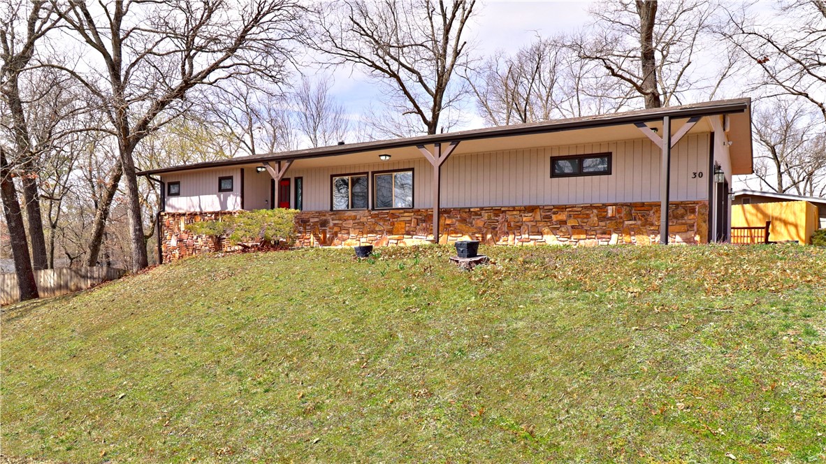 Charming remodeled home with open living room and kitchen for entertaining family and friends. 3 total bedrooms- 2 bedrooms and 2 baths on main level. Bedroom/bonus area and full bathroom in walk-out basement. 2 of the bedrooms have on-suite bathrooms set up like 2 primary bedrooms. Living and kitchen have laminate wood flooring. The kitchen area has granite tops with large countertop/bar top. Separate family room with stone fireplace and a dining area is just off kitchen. Utility room is large and has plenty of room for storage. Nice newly stained back deck. Plus, a patio off 2nd primary bedroom in walk-out basement. Back/side yard has lots of room for gatherings or dogs to run.