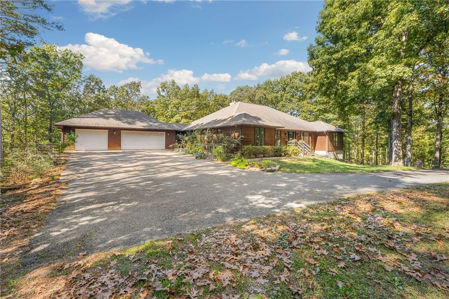 Nestled on 5 wooded acres in an intimate gated community, this luxury estate offers the perfect blend of upscale living and serene privacy just minutes away from Beaver Lake and vibrant downtown Rogers. The spacious custom 4472 sq ft home features a three-car garage and 4 bedrooms, each with its own ensuite bath and walk-in closet - ideal for families or guests seeking comfort and convenience. Soaring ceilings, beautiful hardwoods and fireplaces on both levels enhance the inviting atmospheres. Enjoy formal and casual living spaces, a chef's kitchen with granite counters, high end appliances, and a full second kitchen downstairs for entertaining or a private in-law suite with separate entrance and drive. Entertain or unwind on expansive decks surrounded by breathtaking natural beauty. Gated entry provides piece of mind. Experience refined living in a tranquil setting near all the best NW Arkansas offers.