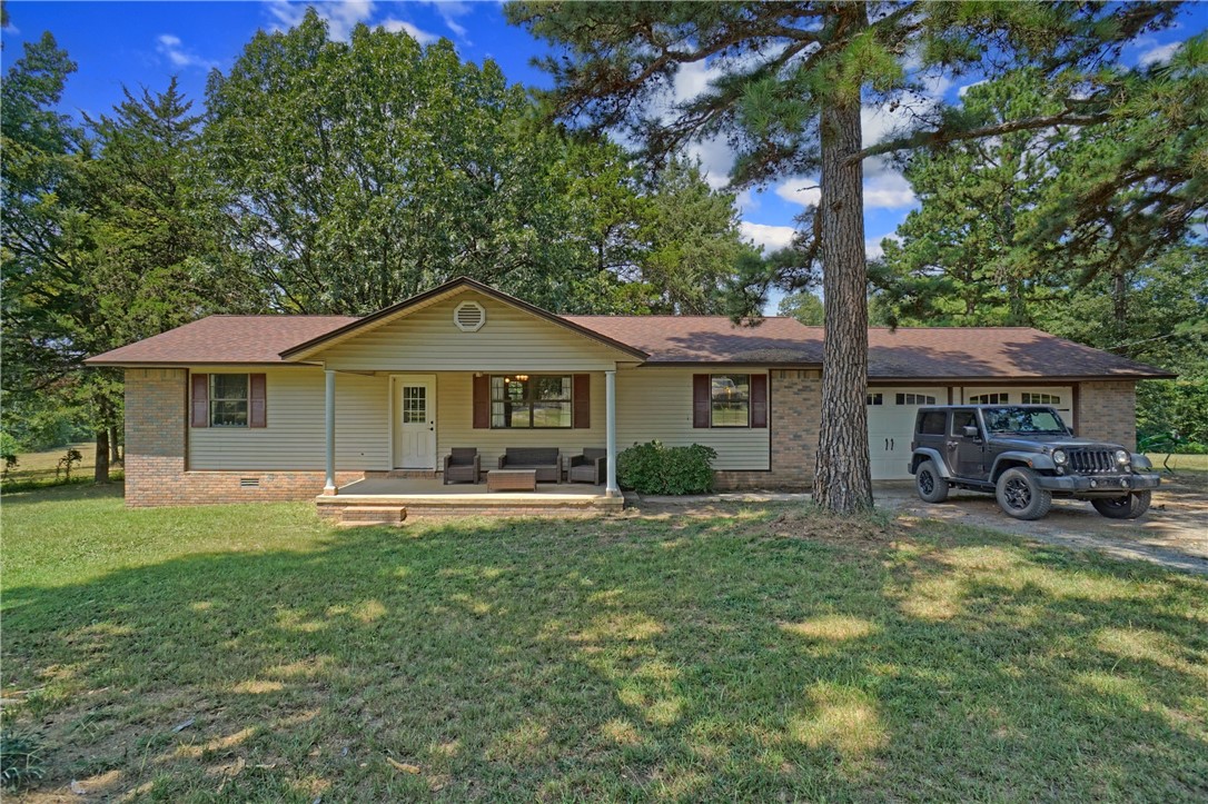 Discover peace and quiet in this beautifully maintained 3-bedroom, 2-bath home on 9.36 acres fenced and with a stocked pond, public water, or well water, and fiber optic internet. With 1,350 sqft of living space, this open-concept floor plan is perfect for relaxed living. Step onto the back deck and soak in natureās beauty, or take advantage of the storage shed and 2-car garage for all your gardening tools and outdoor gear. This home is a true retreat for those seeking comfort, space, and a connection to the outdoors or for someone looking to move out to the country and start a farm but still wants to be within 30 mins of town.