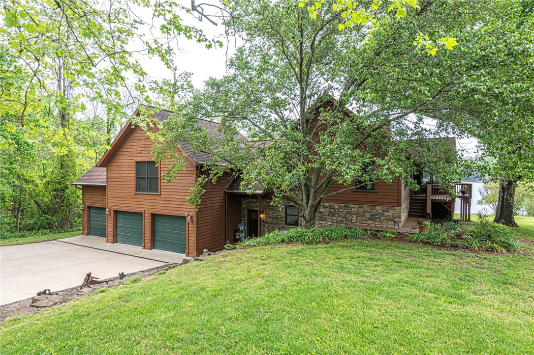 LAKE FRONT/LAKE VIEW HOME! This GORGEOUS 3bd/3 ba cedar lodge w/ full cove & private boat dock is an oasis on 1.617 Acres +/-! Full remodel in 2006! Fresh interior paint throughout! Head inside to the 1st flr w/ workshop/craft room, gym space, storage, & a large bonus rm w/ LVP flooring, 2nd living space, wood burning FP, flex space, & wetbar! 2nd flr (Main) enjoy an open concept feat: Oak hardwood flooring, vaulted ceilings w/ wood beam & plank details, stone wood burning FP, 2 floor-to-ceiling walls of windows, & STUNNING views! Office space off the entry! Relax and rejuvenate in the primary bedroom w/ two walk-in closets with Laundry rm, & private bathroom w/ double sink vanity, jacuzzi tub, and walk-in shower! Plus two additional bedrooms and additional full bathroom! Head out back to the wrap-around deck feat 180Āŗ views of Beaver Lake! Plus easy access to the private boat dock! With 1.617 Acres +/- you'll have plenty of space! More Feat: Wired for Sound, Security System Conveys, Intercom System, and 4 Zone AC!