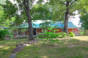 Take a look at this beautiful retreat located in the Ozark mountains of Arkansas! This Property is just minutes from the Buffalo National River, and is only 4 miles from the Jasper Square! This 3 bed 2.5 bath log home sits on 9.88 acres with paved road frontage. Master bedroom leads out to a partially enclosed porch with a monster fireplace. The upstairs also has space for additional beds, giving this property great nightly rental potential. Wooden walkways lead you to a screened in pergola to take in the views with your morning coffee! An additional 1 BR/ 1BA cabin with a loft also sits on the property. 30'x 57' 9 stall horse barn with a small pasture sits to the north of the main house. To top it off is an RV shed with a private septic system and electrical service.