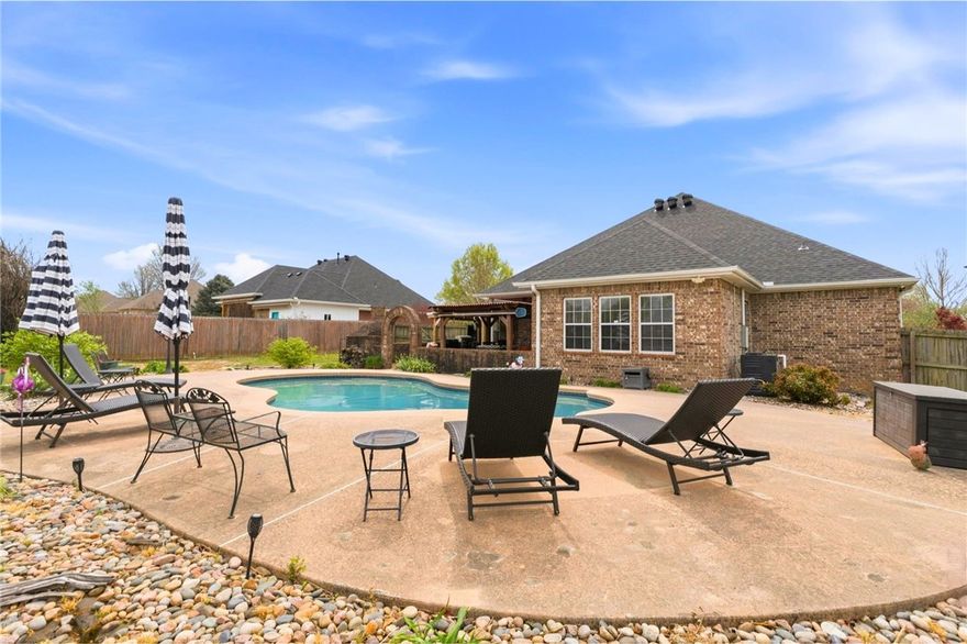 Calling all Razorback fans! If you have been searching for a home you'll be proud to call the Hogs in, this stunning home is it! With 3 spacious bedrooms, an office or craft room, game room & pool table plus a backyard entertainers dream, featuring a large patio & in-ground heated pool, grilling area, sitting area with a cozy brick fireplace, outdoor dining & wired for a hot tub. All of this & more sitting on a large corner lot with oversized side-load garage & extended driveway. With a thoughtfully designed layout, ample indoor & outdoor space, this home has it all. See the attached list of all the updates & features; including a brand new pool heater, extra outlets & lighting outside, central vac, newer wood look tile flooring & appliances.  Located less than 15 mins to the stadium, 6 mins to area Farmington Schools, 15 mins to WRMC hospital, you'll find a variety of shopping, dining & other amenities not far away. Call your favorite real estate professional to see this one in person! Covenants but no active POA.