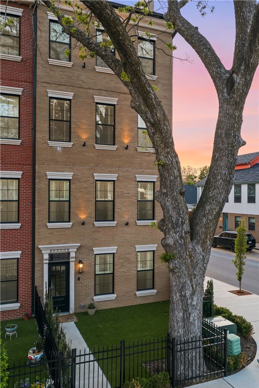 Oak One's flagship — a four-story corner brownstone with 3,042 SF, five bedrooms plus a top-floor bonus room, 4.5 baths, and a private fenced courtyard.
1,200 pounds of hand-set cast stone frame the entry with dentil molding, fluted pilasters, and scroll corbels. Chevron hardwood runs throughout. The main level lives open: chef's kitchen with quartz waterfall island, GE Cafe double-oven range, pot filler, and a great room anchored by a 60-inch fireplace.
The primary suite is a retreat — fireplace, walk-in closet, spa-like bathroom with floating vanity, backlit LED mirror, electric towel rack, and Hansgrohe rain shower.
The fourth floor is the showstopper: a family room beneath Velux skylights with two of Bentonville's most iconic views — the Ledger to the east, the water tower to the north. Sunrise coffee at one window, sunset wine at the other.
Walk to the Square. Adjacent to Gilmore Park and the new STEM university, minutes from Crystal Bridges, the Momentary, and Walmart Home Office.