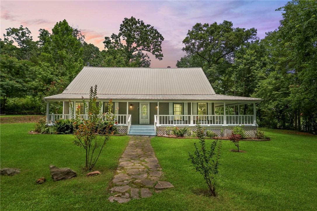 Charming Farmhouse Retreat with Income Potential Near Beaver Lake. Experience the perfect balance of rustic charm and modern comfort in this inviting farmhouse, set on a peaceful 2.07-acre lot in the Monte Ne area. Just minutes from downtown Rogers and the recreational opportunities of Beaver Lake, this property offers a serene countryside atmosphere with convenient access to city amenities. The home features classic vinyl siding, a durable metal roof, and two wood-burning fireplaces that bring warmth and character to the living spaces. Central heating and cooling systems provide year-round comfort. The expansive outdoor area includes a blend of cleared and wooded sections, offering both open space and natural privacy. With its location near popular destinations, this property presents strong potential for use as a short-term rental or vacation home. The combination of timeless charm, modern amenities, and proximity to outdoor recreation makes this a unique and appealing opportunity.